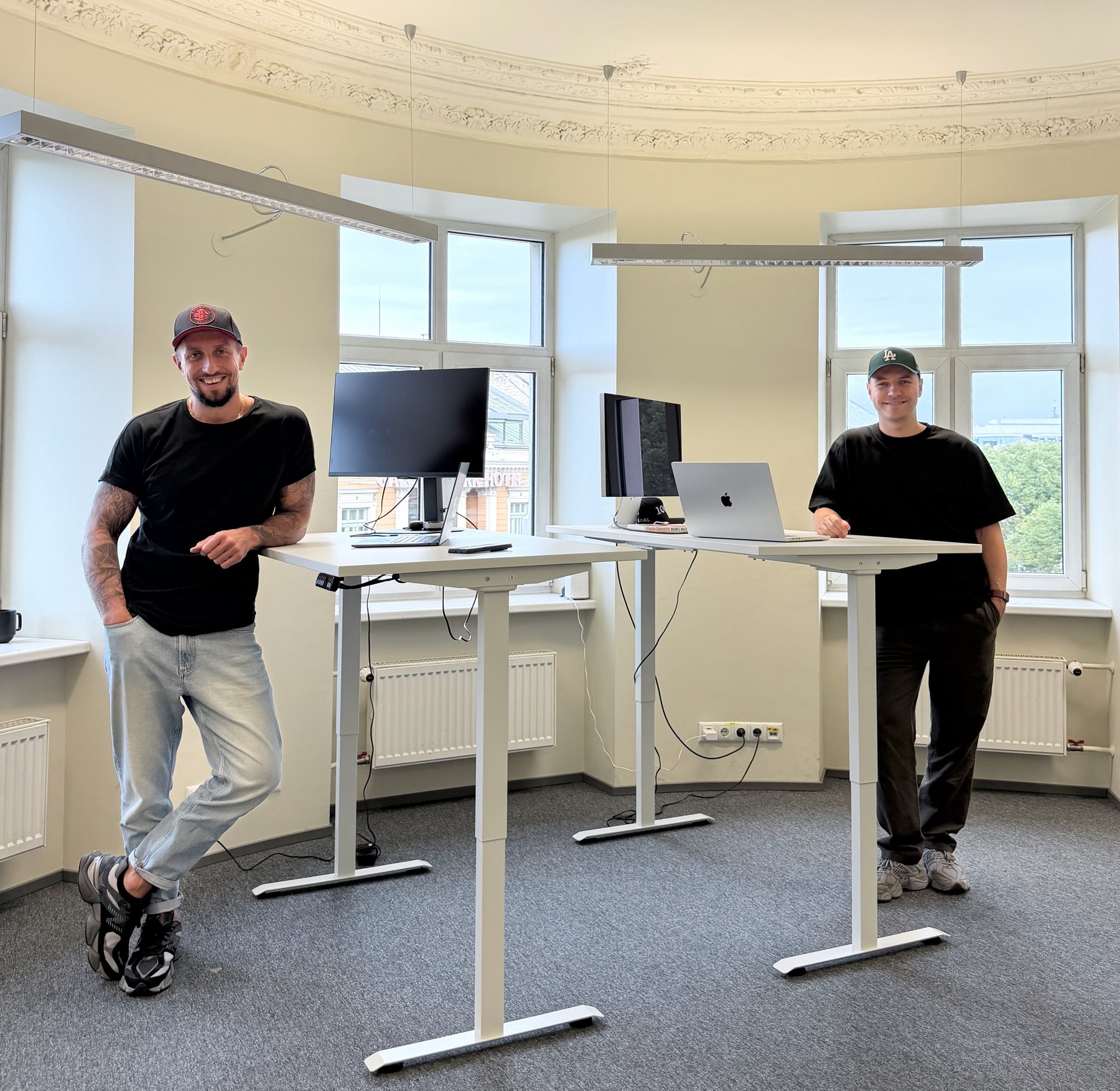 The two travelque founders standing at their desks in the company’s office