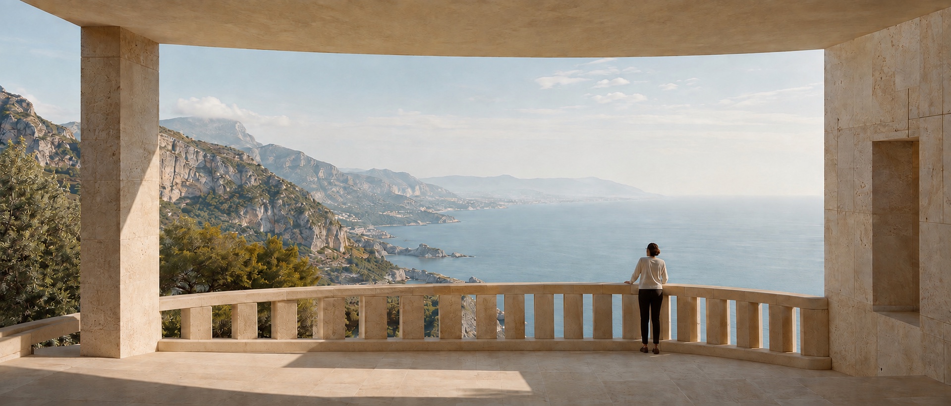 A person looking out over the coastline from a sunlit stone terrace